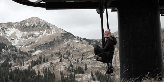 Woman sitting on a ski lift looking at mountain side