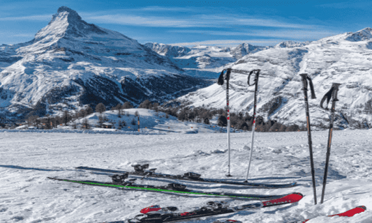 Two pairs of skis and poles on a ski slope