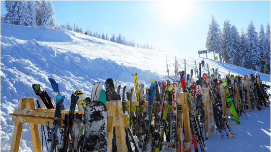 Skis and snowboards on a ski rack at a ski resort