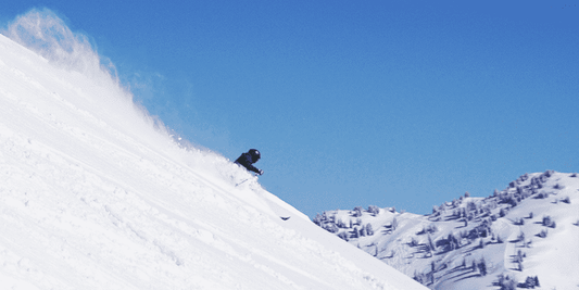 Person skiing in deep powder on a bluebird day